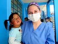 Female medical student with a child on her hips pose for the camera