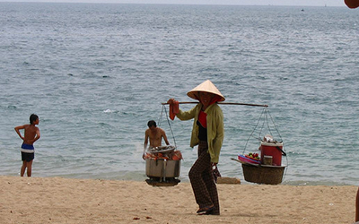 Vietnamese women walks along beach
