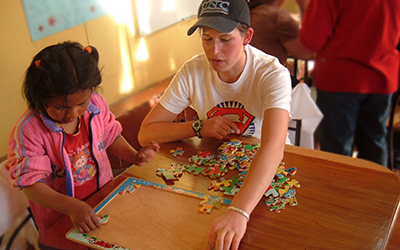 Male volunteer does a puzzle with young child