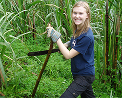 Female volunteer poses with bamboo stick