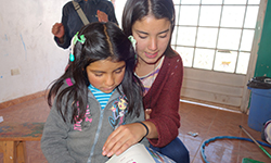 Female volunteer reads to young Peruvian child