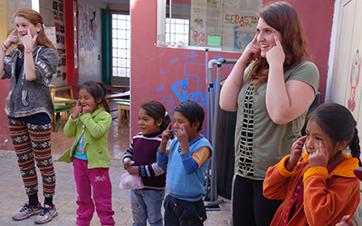Volunteers play games with children in Peru